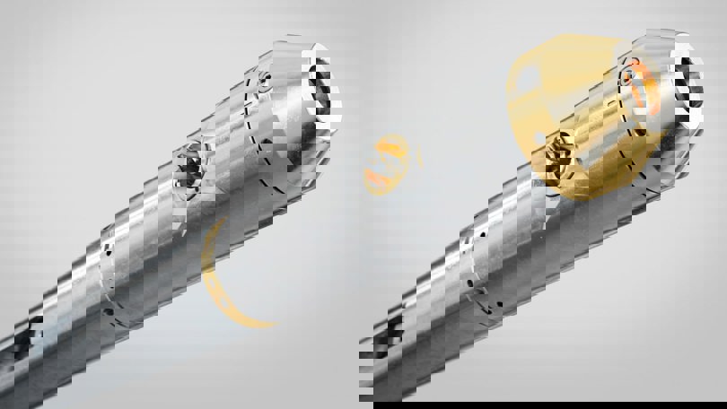Close up of a metallic downhole tool with gold-colored components, designed for precision cutting or milling operations.